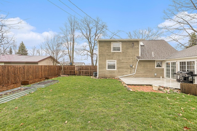 back of house featuring a patio, a fenced backyard, roof with shingles, and a yard