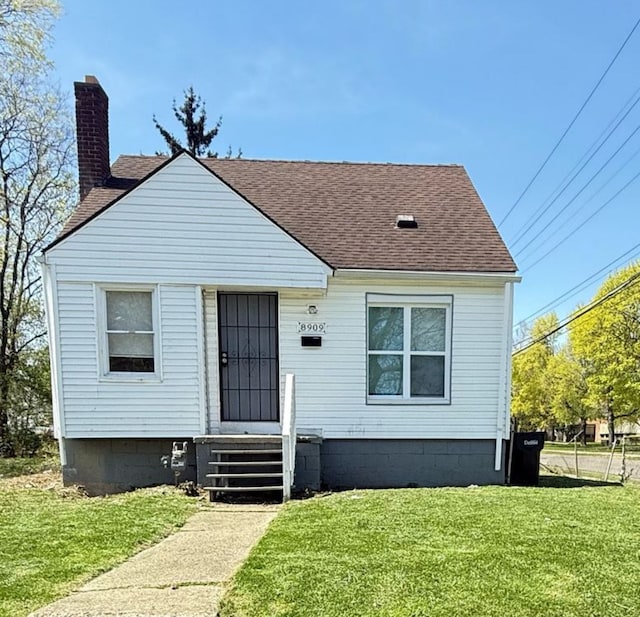 8909 Penrod St, Detroit, MI 48228 - bungalow-style home featuring roof with shingles, a chimney, and a front yard
