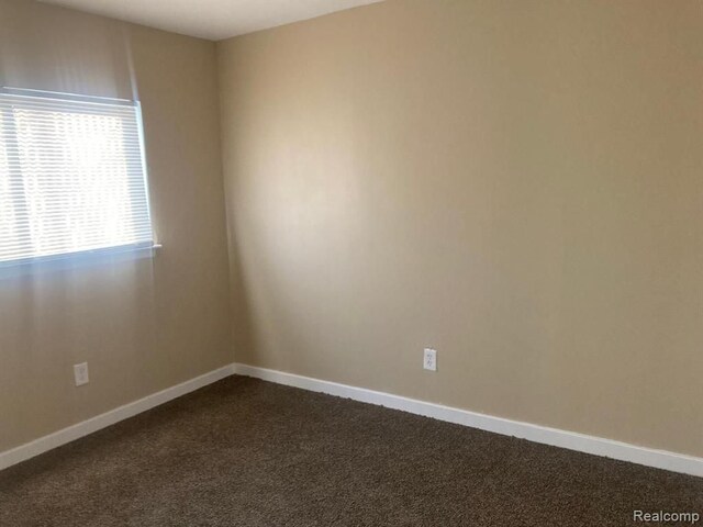 20442 Greenlawn St, Detroit, MI 48221 - empty room with baseboards and dark carpet
