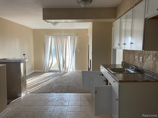 20442 Greenlawn St, Detroit, MI 48221 - kitchen with a sink, light carpet, dark countertops, white cabinets, and decorative backsplash