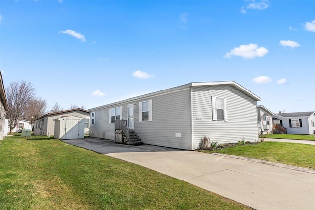 view of front of house featuring an outbuilding, a storage unit, and a front yard