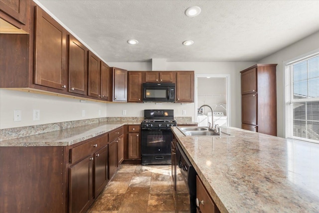 kitchen with recessed lighting, a textured ceiling, a sink, light stone countertops, and black appliances