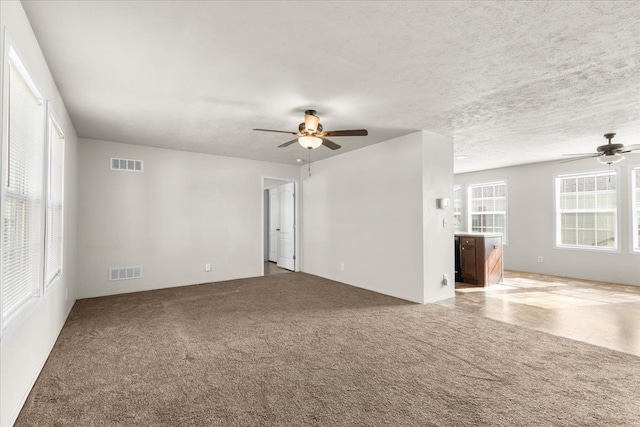 spare room with visible vents, ceiling fan, and carpet