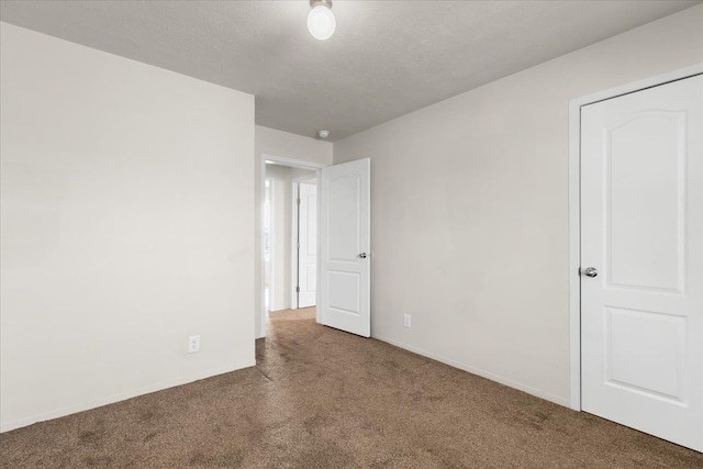 unfurnished bedroom featuring baseboards, carpet flooring, and a textured ceiling