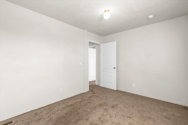 empty room featuring carpet floors and visible vents