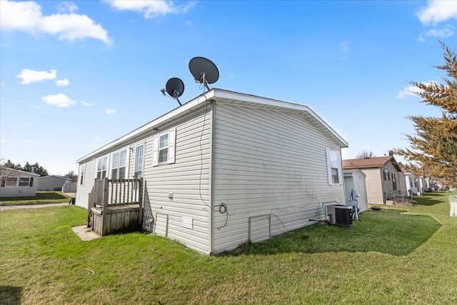 view of side of home with a lawn and cooling unit