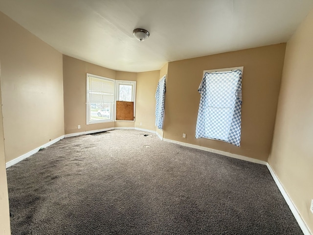 carpeted spare room featuring baseboards