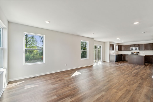 unfurnished living room with baseboards, recessed lighting, wood finished floors, and visible vents