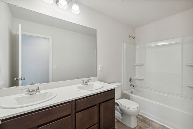 full bathroom featuring double vanity, a sink, shower / bathtub combination, and toilet