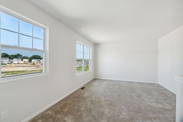 carpeted empty room featuring baseboards and visible vents