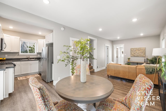 135 Houseman Ave NE, Grand Rapids, MI 49503 - dining space featuring wood finished floors, recessed lighting, and stairs