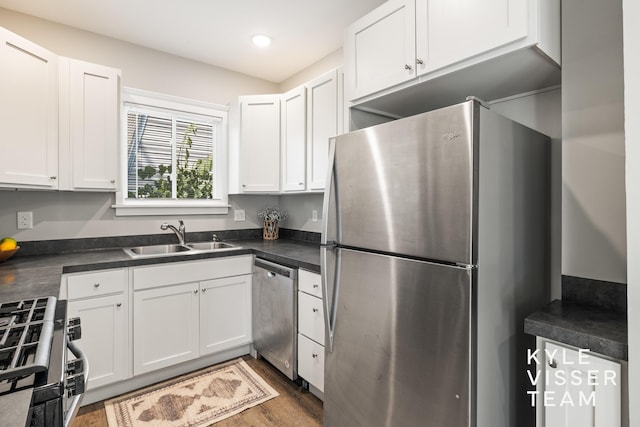 135 Houseman Ave NE, Grand Rapids, MI 49503 - kitchen featuring appliances with stainless steel finishes, dark countertops, white cabinets, dark wood-style floors, and recessed lighting
