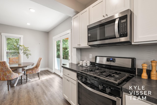 135 Houseman Ave NE, Grand Rapids, MI 49503 - kitchen with appliances with stainless steel finishes, dark countertops, healthy amount of natural light, wood finished floors, and recessed lighting