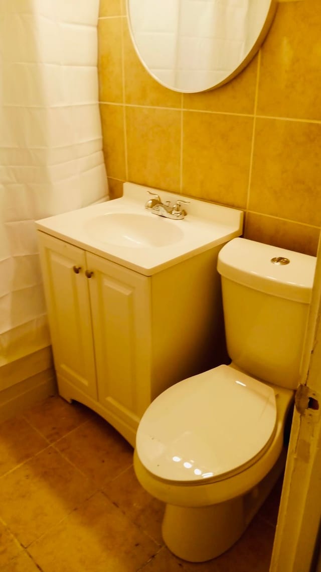 22118 Ulster St, Detroit, MI 48219 - bathroom with tile walls, tile patterned floors, vanity, and toilet