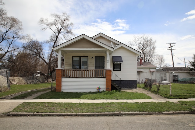 bungalow-style house featuring a front yard, a porch, and fence
