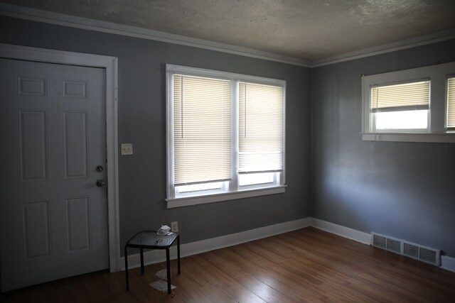 entryway featuring wood finished floors, baseboards, visible vents, and a wealth of natural light