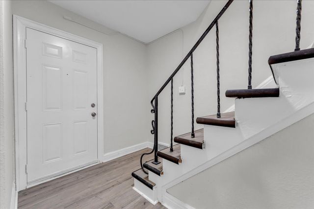 foyer entrance with baseboards, stairway, and wood finished floors