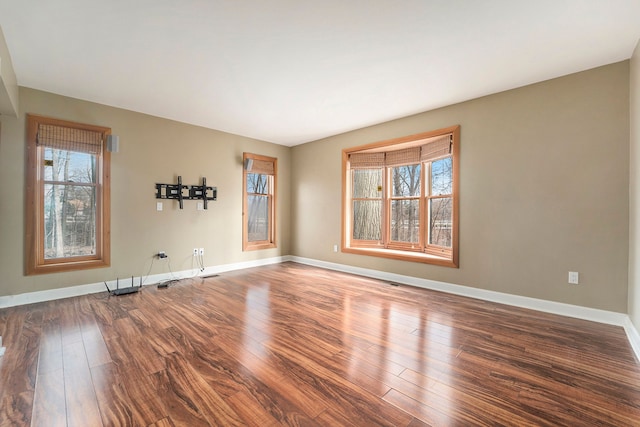 empty room featuring baseboards and wood finished floors
