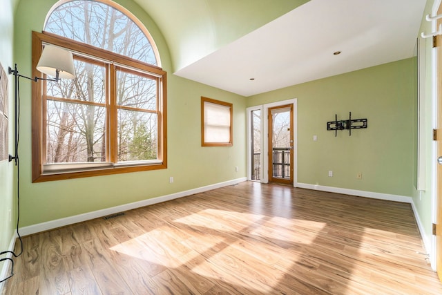 unfurnished room with wood finished floors, baseboards, and visible vents