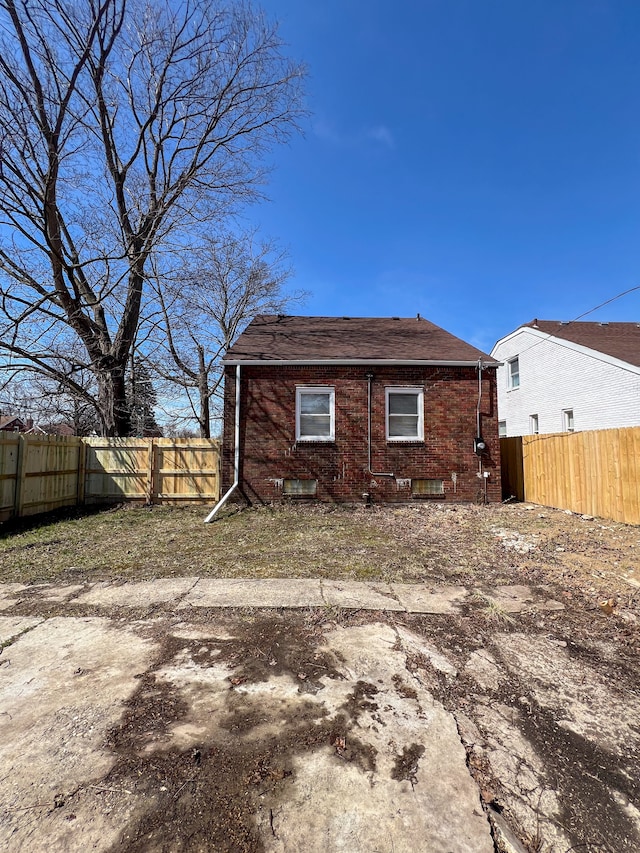 rear view of property featuring a fenced backyard