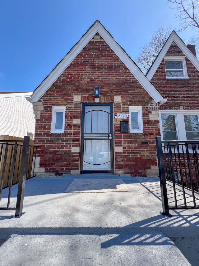 property entrance featuring brick siding and fence
