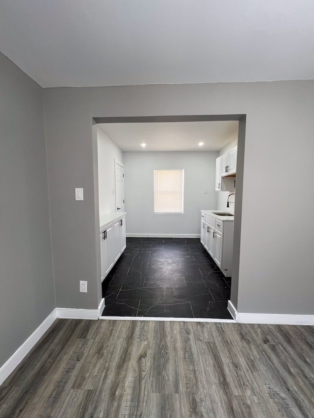 interior space with vanity, baseboards, and wood finished floors