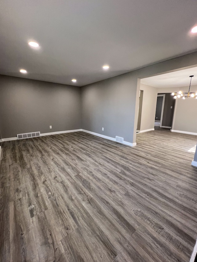 unfurnished living room featuring dark wood-style flooring, visible vents, baseboards, and recessed lighting