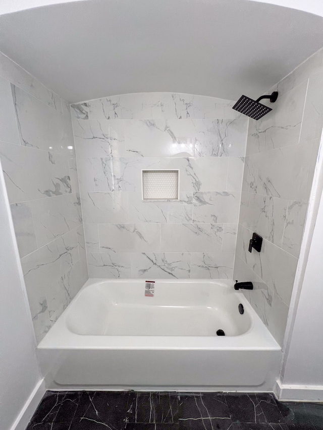 bathroom featuring baseboards, marble finish floor, and tub / shower combination