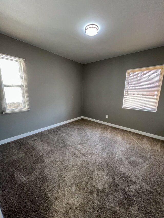 carpeted spare room featuring baseboards
