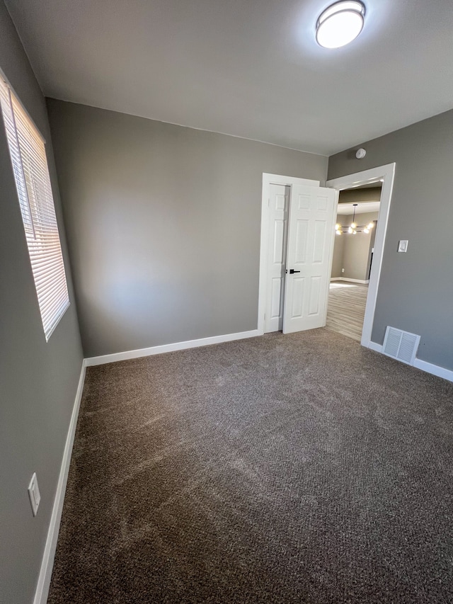 spare room featuring visible vents, baseboards, and carpet floors