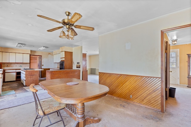 2975 Hadden Rd, Rochester, MI 48306 - dining space with wood walls, concrete floors, a wainscoted wall, and ceiling fan