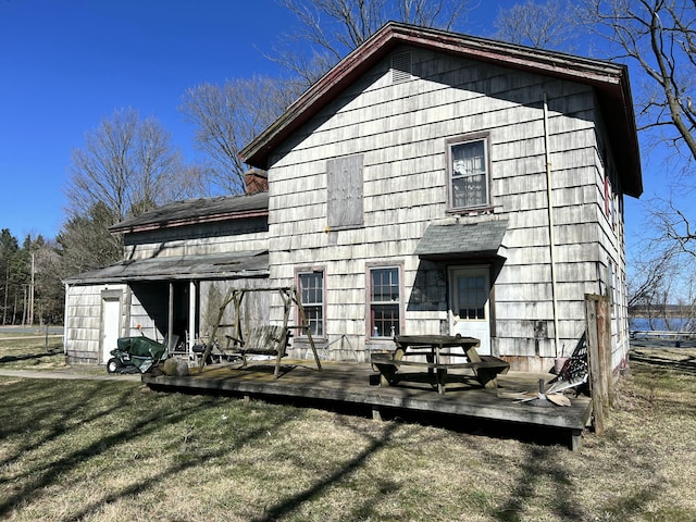 back of property with a wooden deck and a yard