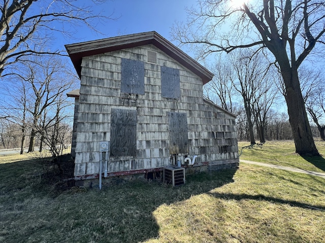 view of side of home featuring a lawn and an outdoor structure
