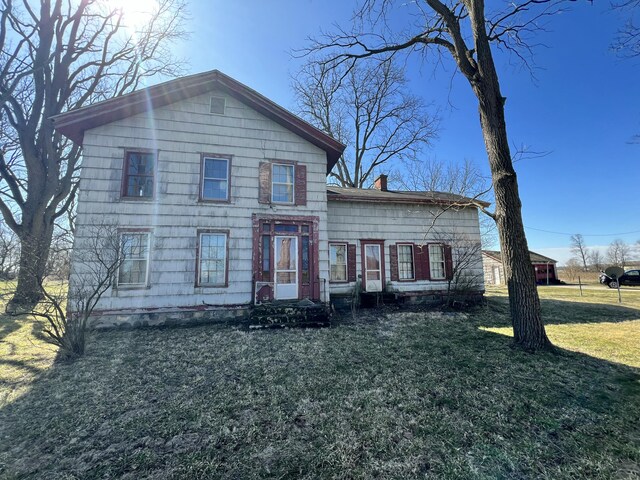 view of front of home featuring a chimney and a front yard