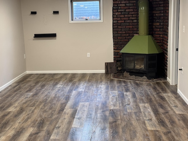 617 Cherry Ave, Big Rapids, MI 49307 - unfurnished living room with baseboards, wood finished floors, and a wood stove