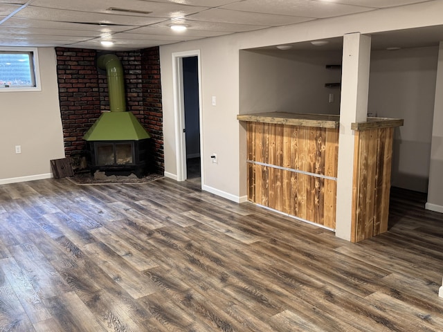 617 Cherry Ave, Big Rapids, MI 49307 - basement with a drop ceiling, indoor bar, a wood stove, and wood finished floors