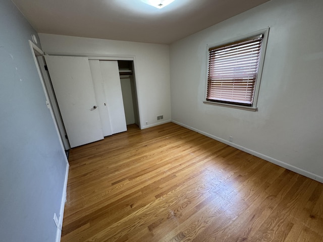 617 Cherry Ave, Big Rapids, MI 49307 - unfurnished bedroom with a closet, baseboards, visible vents, and light wood-type flooring