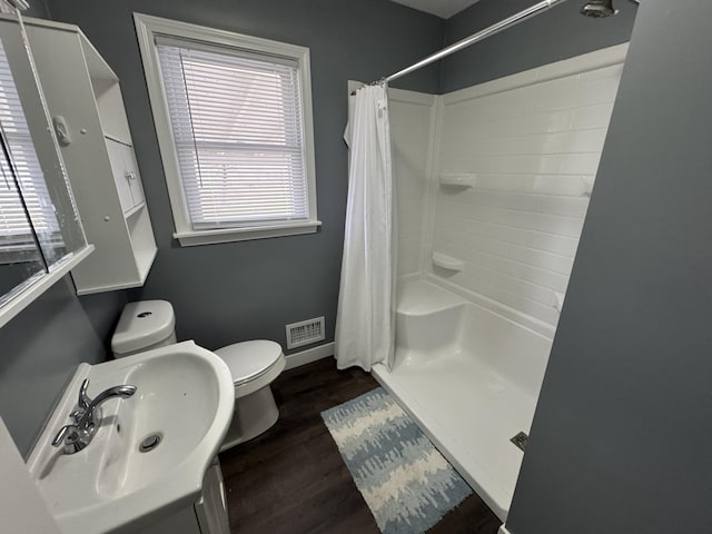 617 Cherry Ave, Big Rapids, MI 49307 - full bathroom with visible vents, baseboards, toilet, wood finished floors, and curtained shower
