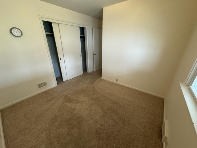 617 Cherry Ave, Big Rapids, MI 49307 - unfurnished bedroom with carpet flooring, baseboards, a closet, and visible vents