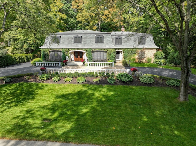 45778 Fermanagh Dr, Northville, MI 48168 - front facade with a wooded view, a front yard, french doors, and a chimney
