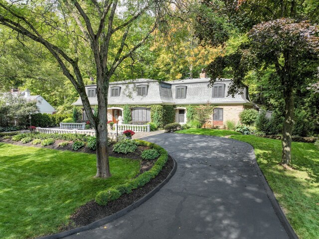 45778 Fermanagh Dr, Northville, MI 48168 - view of property with a front lawn, brick siding, curved driveway, and a chimney