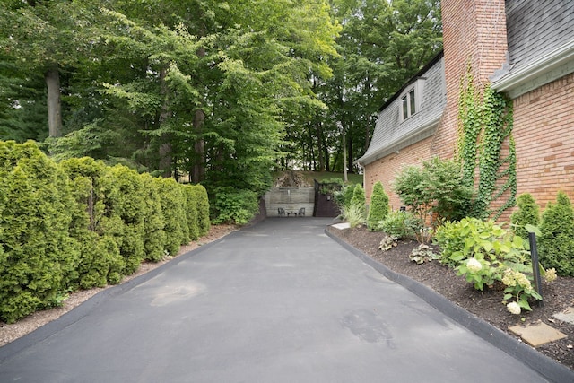 45778 Fermanagh Dr, Northville, MI 48168 - view of property exterior with mansard roof, a chimney, and brick siding