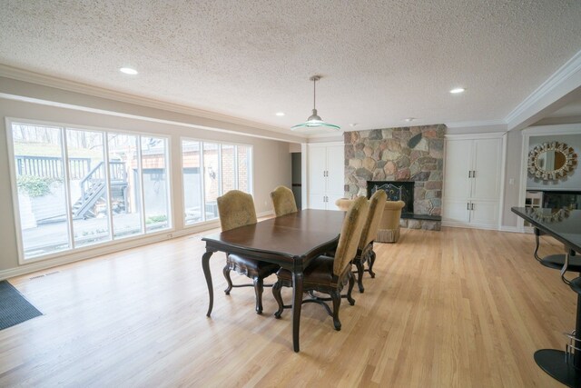 45778 Fermanagh Dr, Northville, MI 48168 - dining area featuring recessed lighting, light wood-style flooring, ornamental molding, a fireplace, and a textured ceiling