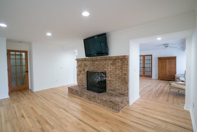 45778 Fermanagh Dr, Northville, MI 48168 - unfurnished living room featuring light wood-type flooring, recessed lighting, ornamental molding, a fireplace, and french doors