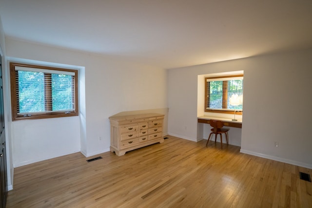 45778 Fermanagh Dr, Northville, MI 48168 - empty room featuring visible vents, light wood finished floors, built in desk, and baseboards
