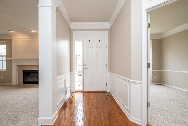 49128 Rainbow Ln S, Northville, MI 48168 - entryway featuring crown molding, a wainscoted wall, wood finished floors, and a tile fireplace