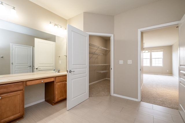 49128 Rainbow Ln S, Northville, MI 48168 - full bathroom featuring a sink, double vanity, baseboards, and a walk in closet