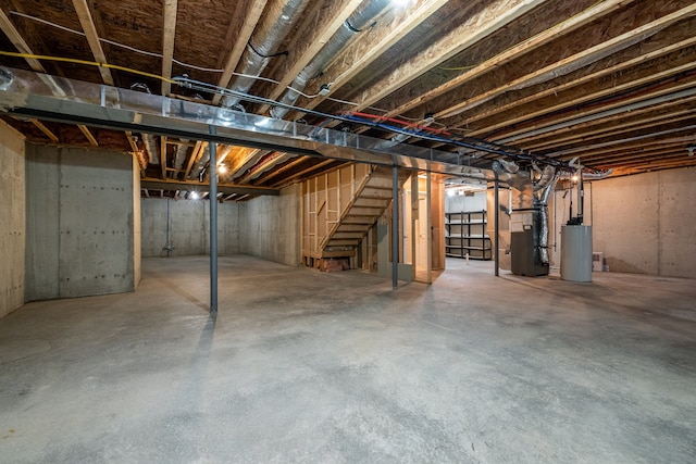 49128 Rainbow Ln S, Northville, MI 48168 - unfinished basement with gas water heater, heating unit, and stairway