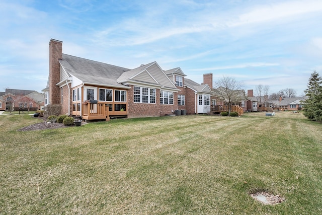 49128 Rainbow Ln S, Northville, MI 48168 - back of property featuring a chimney, a wooden deck, a yard, and brick siding