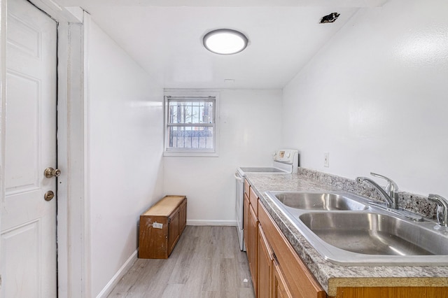 kitchen with baseboards, a sink, white range with electric cooktop, light wood-type flooring, and brown cabinetry